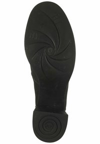Suela de zapato de goma negra con un patrón en espiral y la inscripción "FLY". Presenta un tacón circular con una superficie texturizada y una ligera curvatura.