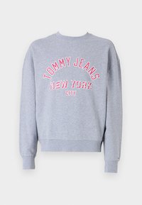 Light gray sweatshirt made of cotton blend, featuring a crew neck and ribbed cuffs. Displays “TOMMY JEANS NEW YORK CITY” in red embroidery.