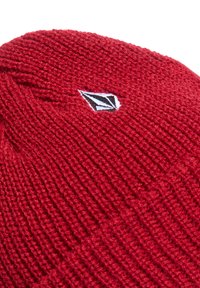 Rode gebreide beanie met een textuurpatroon, voorzien van een klein zwart-wit logo-opdruk. Het ontwerp is eenvoudig, met een aansluitende vorm.