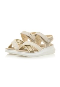 Sandali beige con fasce incrociate, realizzati in materiale morbido. Presentano un mix di dettagli in rete e finiture lisce, e una suola bianca leggera.