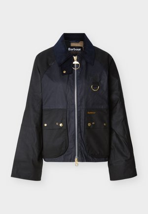 Veste en coton ciré bleu marine avec col en velours côtelé, finitions en métal doré, deux poches avant, et fermeture éclair. Logo de la marque sur la poche gauche.