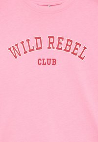 Rosa bomullströja med "WILD REBEL" i vitt och "CLUB" i rött, med en bågformad textdesign och rundad halsringning.