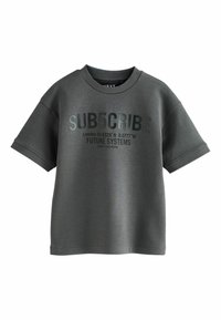 Tricou din bumbac gri, cu mâneci scurte, având un text îndrăzneț negru: "SUB5CRIBE" și coordonate geografice. Guler rotund și croi lejer.