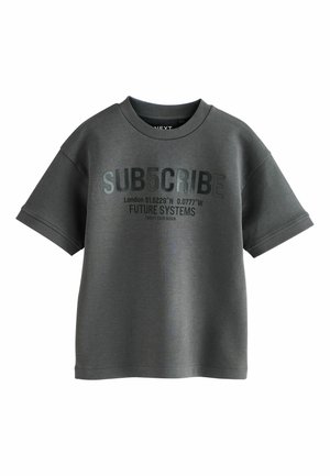 T-shirt gris à manches courtes avec un col rond, présentant un texte en relief : "SUB5CRIBE," des coordonnées et "FUTURE SYSTEMS" en couleur contrastante.