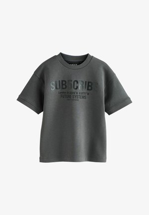 Tricou gri cu mâneci scurte și guler rotund, prezentând un text embossat: "SUB5CRIBE," coordonate și "FUTURE SYSTEMS" într-o culoare contrastantă.