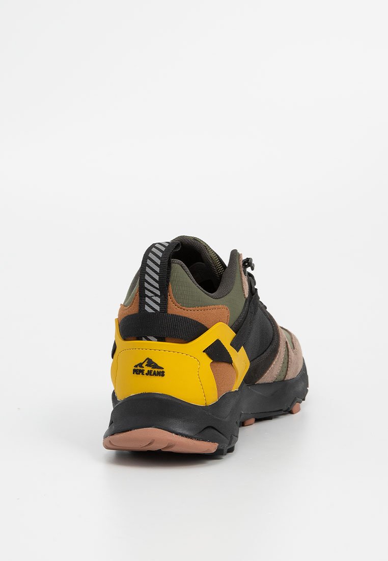 Achteraanzicht van een multicolor sneaker met zwarte, groene, bruine en gele secties, textielstof en een prominent logo. Rubberen zool.