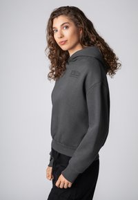 Grijze sweatshirt gemaakt van een katoenmix, met een voorvak in kangoeroestijl, ribgebreide manchetten en een relaxte pasvorm. Eenvoudige tekstdetail op de borst.
