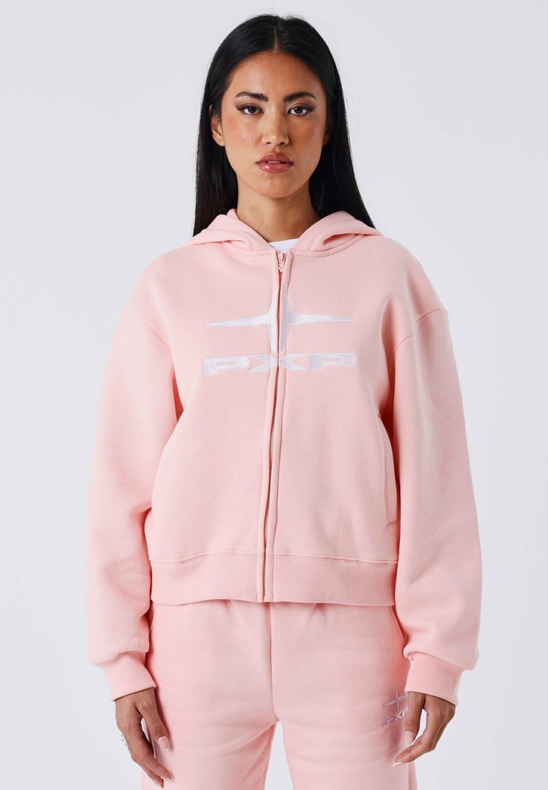 Lichtroze zip-up hoodie gemaakt van zachte stof, met een voorzak en een wit logo. De capuchon trekt de aandacht met zijn relaxte ontwerp.