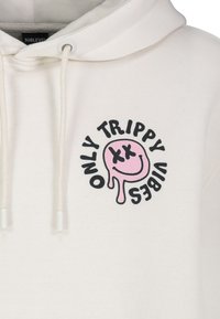Weißes Kapuzensweatshirt mit Kordeln, das ein rundes schwarzes und pinkes Grafikdesign zeigt, auf dem "ONLY TRIPPY VIBES" mit einem Smiley-Gesicht steht.