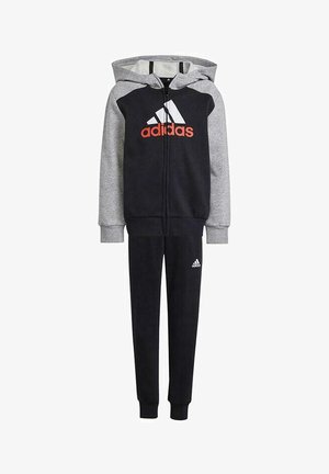 Chándal Adidas en azul marino y gris, que incluye una sudadera con cremallera y un logo prominente, junto con pantalones de chándal a juego con puños en los tobillos.