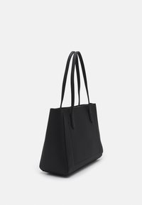 Czarna torba typu tote z teksturowaną powierzchnią, ostrym designem, solidną płaską podstawą i dwoma długimi uchwytami, wyposażona w przednią kieszeń dla dodatkowej funkcjonalności.