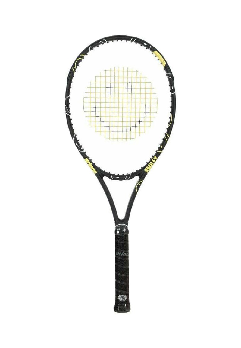 Zwarte tennisracket met gele snaren die een glimlachend gezicht ontwerp vormen op een witte achtergrond.