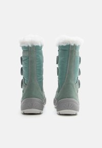 Botas de nieve verdes con un suave forro de piel blanca, material de ante e impermeable, que cuentan con tres correas ajustables de Velcro y una suela gris texturizada.