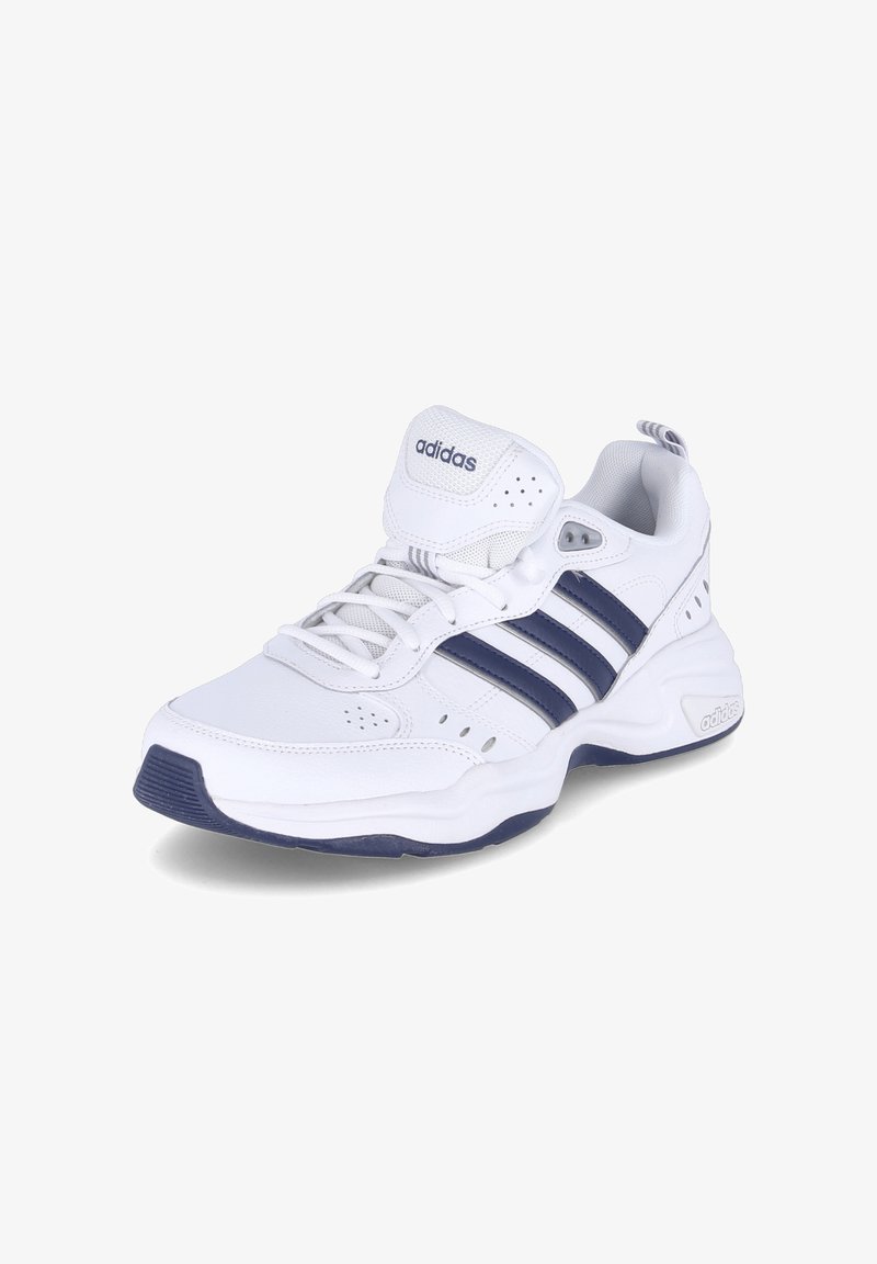 White athletic shoe with navy blue accents, perforated sides, lace-up design, cushioned ankle, and textured sole. Features Adidas logo.