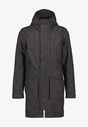 Cazadora negra larga e impermeable con capucha, que cuenta con grandes bolsillos frontales, un bolsillo en el pecho con cremallera y puños ajustables. Textura lisa y mate.