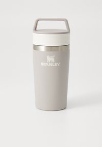 Gray insulated travel mug with a white lid, carrying handle, and stainless steel band. Features "STANLEY" logo in white. Smooth finish.