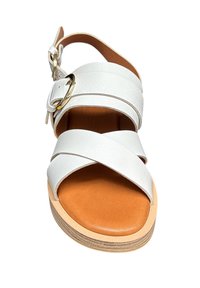 Sandales en cuir blanc avec un design à brides croisées, une bride à la cheville avec boucle et une semelle intérieure rembourrée de couleur marron clair. Présente une semelle en couches ressemblant à du bois.