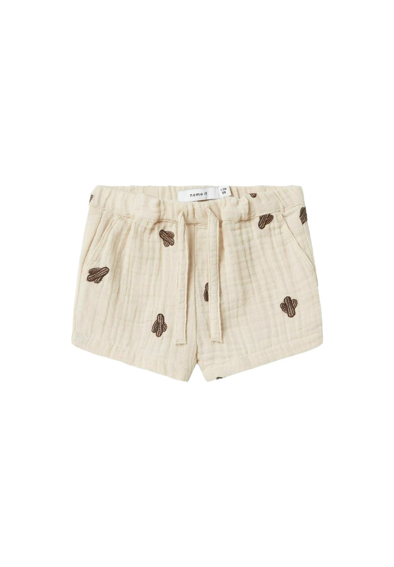 Shorts en coton beige avec une finition texturée, ornés d'une broderie de cactus marron, dotés d'une taille élastique et d'un cordon de serrage pour l'ajustement.
