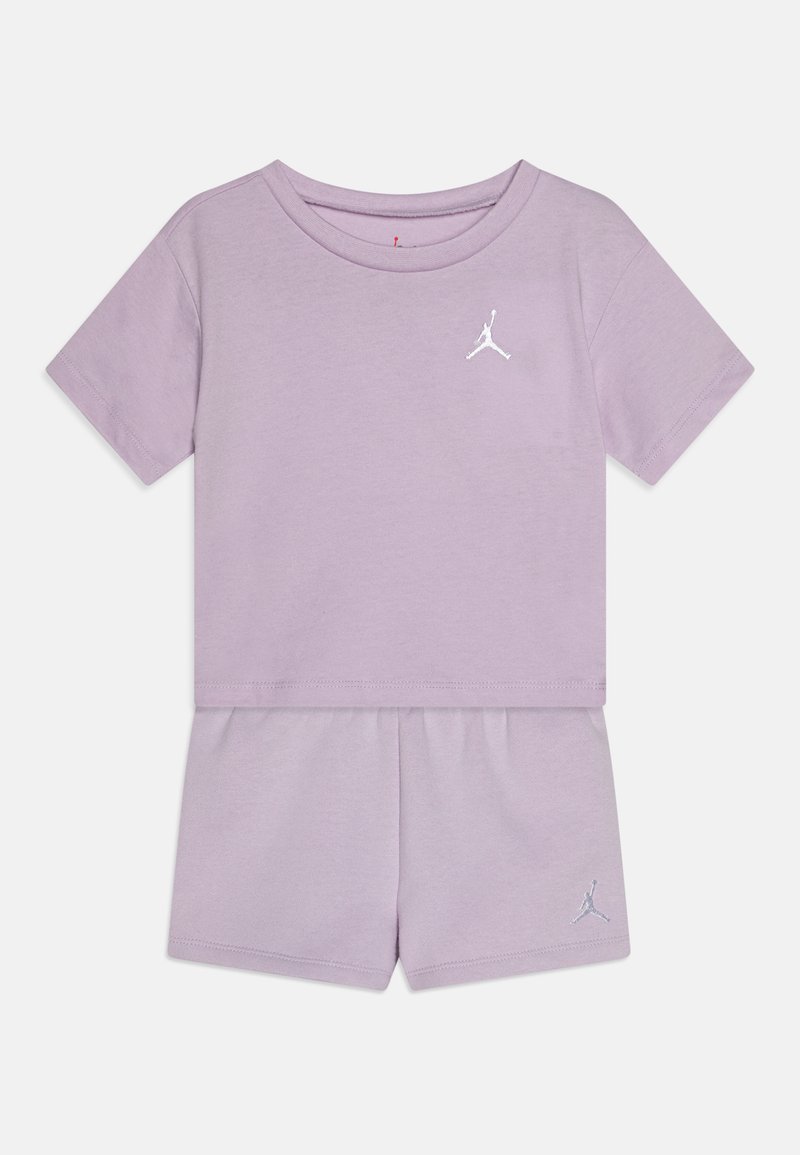 Šviesiai violetinės spalvos trumpomis rankovėmis marškiniai ir šortai, pagaminti iš minkštos medvilnės, su baltu Jumpman logotipu ant krūtinės ir šortų apatinės dalies.