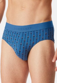Heren blauwe boxershorts met een gestreept patroon met verticale lijnen en accenten. De tailleband toont de merknaam "Schiesser."