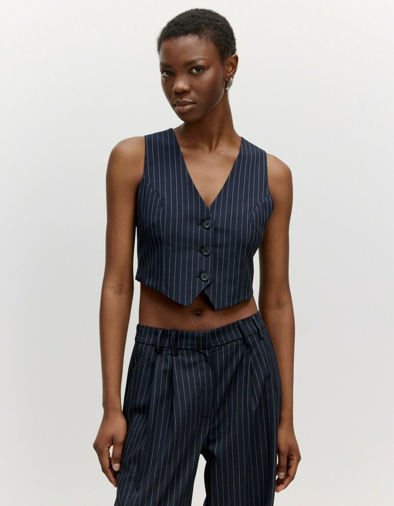 Marineblau gestreifter, kurz geschnittener Weste, ärmellos, mit tiefem V-Ausschnitt, drei Knöpfen vorne und passenden, hoch sitzenden, gestreiften Hosen.