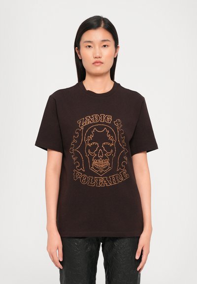 Schwarzes Baumwoll-T-Shirt mit einem großen metallisch goldenen Totenschädel-Graphic, das mit komplizierten Mustern verziert ist, kurzen Ärmeln und einem klassischen Rundhalsausschnitt.