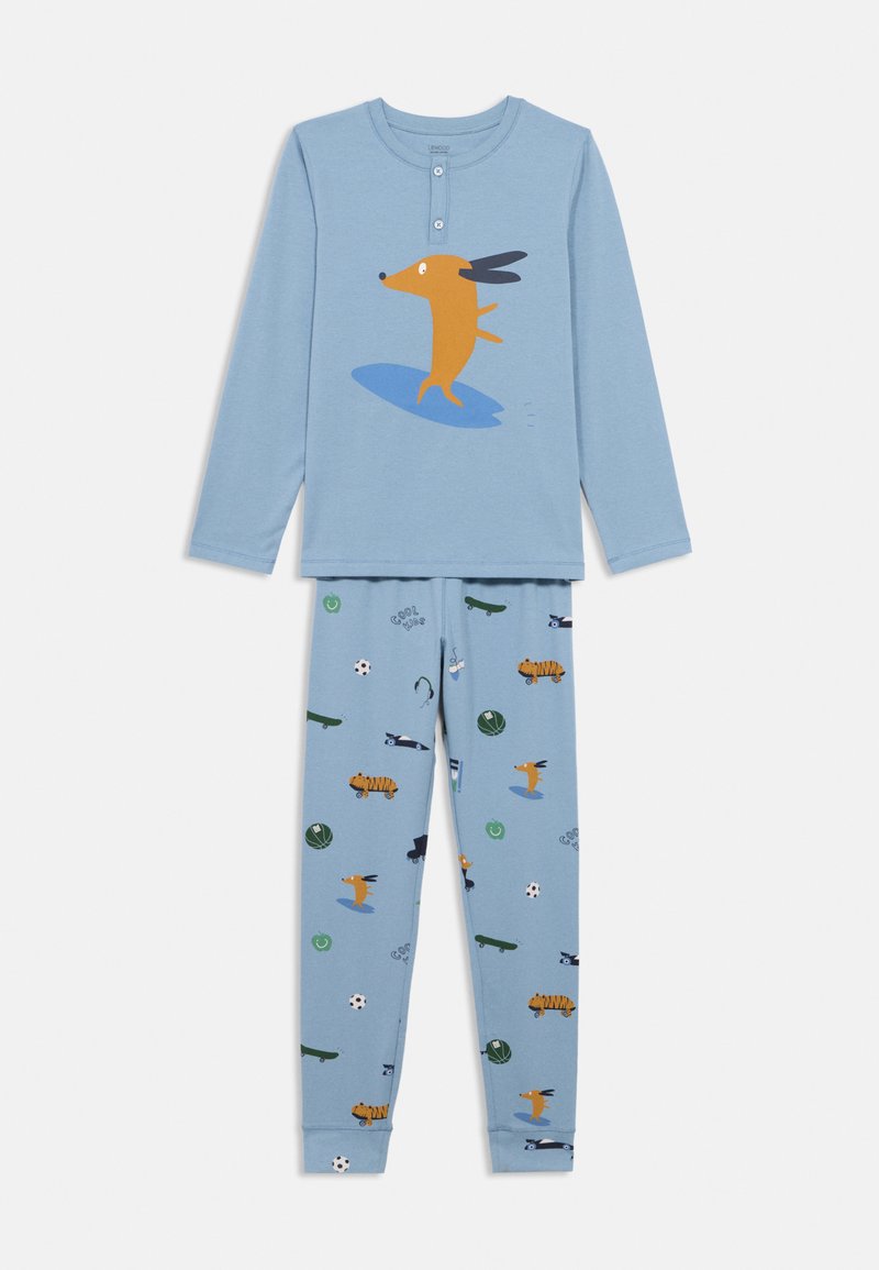 Μπλε πυτζάμες που περιλαμβάνουν ένα μακρυμάνικο μπλουζάκι με γραφικό ενός πορτοκαλί σκύλου που κάνει σερφ και μπλε παντελόνια με διάφορα παιχνιδιάρικα σχέδια.