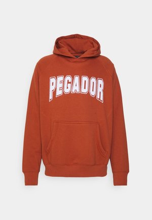 Sweat à capuche orange rouille avec poche avant et texte blanc en gras "PEGADOR" sur la poitrine.