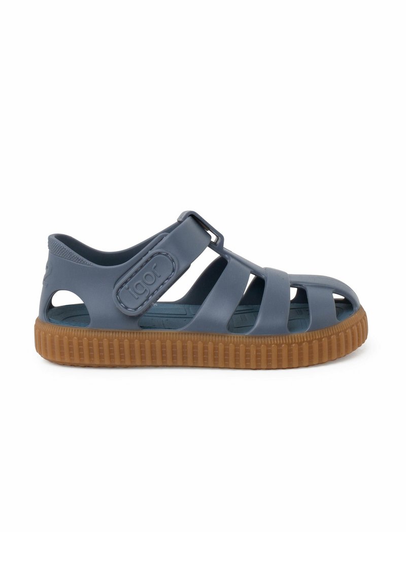 Blue rubber sandal with open design, adjustable strap, and brown textured sole. Features cutouts for ventilation and a logo detail.