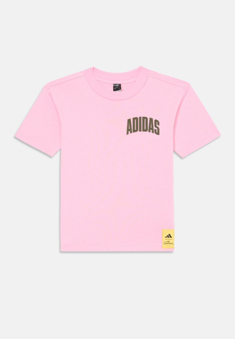Camiseta rosa de manga corta, con un logo curvado en verde oscuro que dice "ADIDAS" en el pecho y una etiqueta de acento amarilla en el dobladillo. Material de algodón.