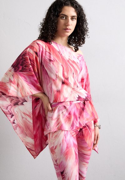 Top largo e pantaloni coordinati in tessuto rosa con un motivo simile a piume. Il top ha un design scollato sulle spalle e un orlo a strati.