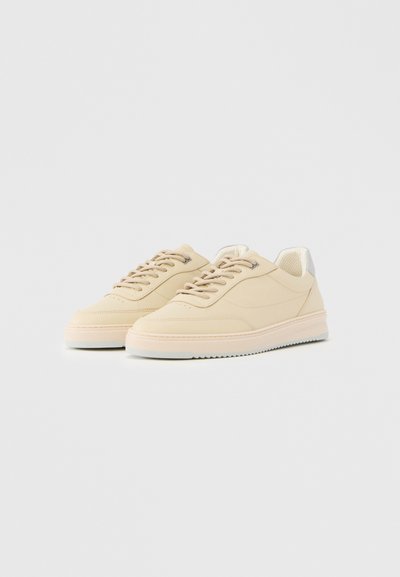 Beezhist värvi madala säärega tossud nööpidega, heledate talladega ja veidi polsterdatud kaelusega, lihtsal valgel taustal.