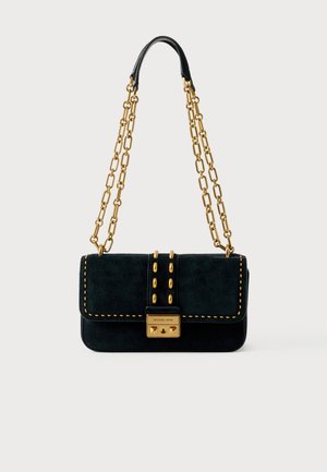 Schwarze Wildlederhandtasche mit goldener Kettenriemen, goldenen Nietenakzenten auf der vorderen Klappe und rechteckigem goldenen Verschluss mit eingraviertem Markennamen.