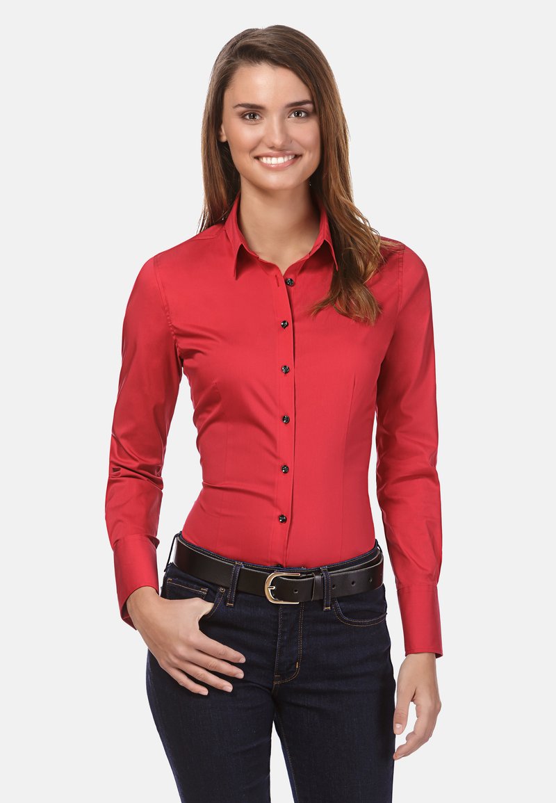 Rode fitted shirt met lange mouwen en zwarte knopen, gecombineerd met donkere jeans en een zwarte riem. Soepele stof, op maat gemaakt ontwerp, formele stijl.