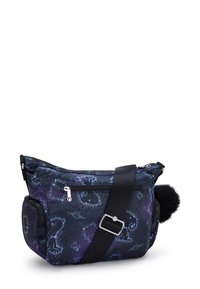 Crossbody taske med galakse- og stjernebilledeprint, sort justerbar rem, frontlomme med lynlås og sort pom-pom fastgjort på siden.