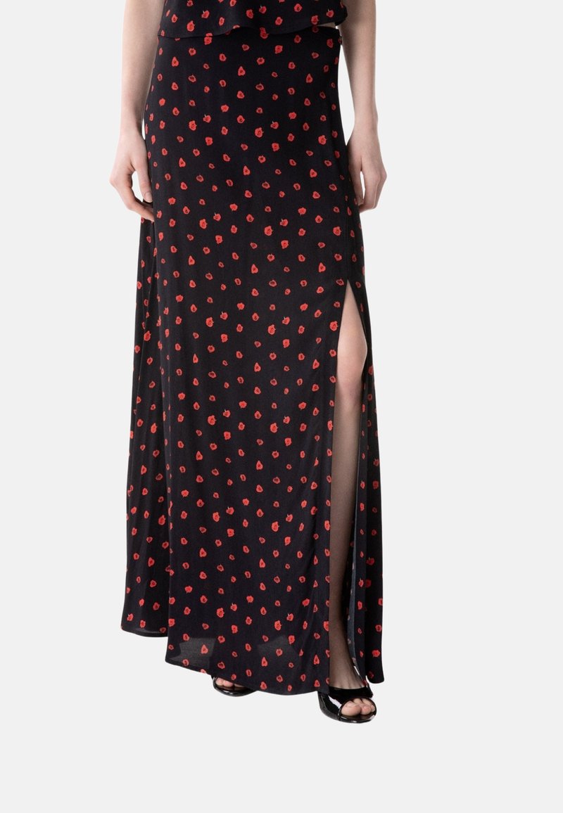 Schwarzer Maxirock mit kleinem roten Blumenmuster und hohem Beinschlitz, getragen mit schwarzen offenen High Heels, gezeigt von der Taille bis zu den Füßen.