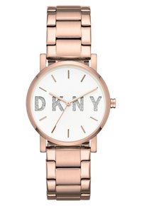 Orologio color oro rosa con quadrante rotondo, dial bianco e logo "DKNY" in argento. Presenta un bracciale in metallo a maglie con finitura lucida e indicatori delle ore minimalisti.