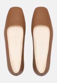 Ballerine in pelle marrone con una texture liscia, design a punta quadrata e ritagli ai lati. La fodera interna è di colore chiaro.