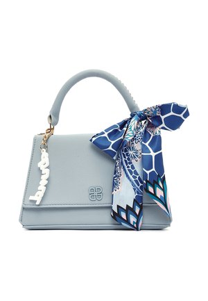 Lichtblauwe leren handtas met handvat bovenop, een blauw patroon sjaal vastgebonden aan het handvat, en een witte decoratieve hanger aan de zijkant.