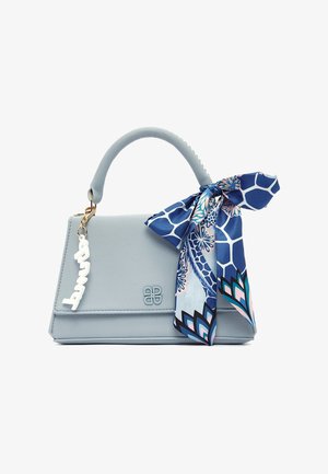 Light blue leather handbag with top handle, a blue patterned scarf tied to the handle, and a white decorative charm hanging on the side.