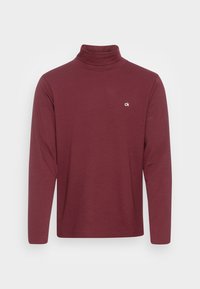 Burgundy långärmad polotröja i bomull, med en liten vit logotyp på bröstet. Slät textur, åtsittande design.