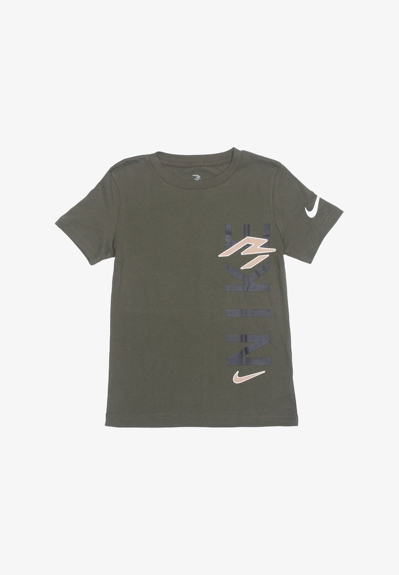 T-shirt Nike manches courtes vert olive avec texte "NIKE" noir vertical, logos Swoosh beige sur la poitrine et la manche gauche.
