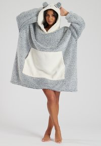 Sudadera gris de gran tamaño con acentos en blanco y una textura suave y esponjosa. Cuenta con un bolsillo tipo canguro y orejas de oso en la capucha.