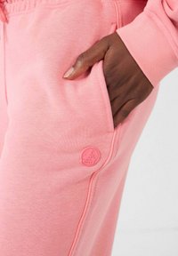 Roze katoenen jogger pants met zijzakken en een bijpassende merklogo patch. Mouwen hebben ribbels voor een comfortabele pasvorm.