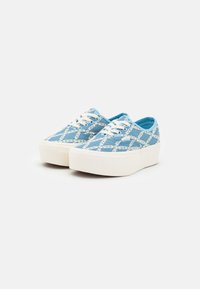 Blue canvas sneakers with a white pattern, round toe, white rubber sole, and lace-up design. Platform style adds height.
