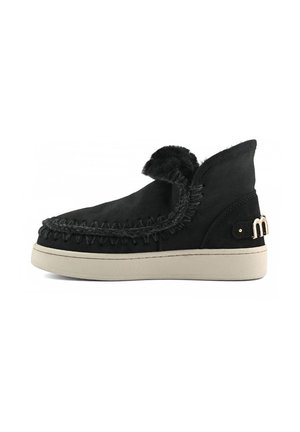 Stivale alla caviglia in suede nero con dettagli in pelliccia, cuciture decorative e suola in gomma beige. Presenta un dettaglio in metallo dorato sul lato.