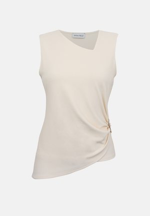 Haut beige sans manches avec un col asymétrique et un détail froncé sur le côté, rassemblé par un anneau décoratif sur la hanche droite.