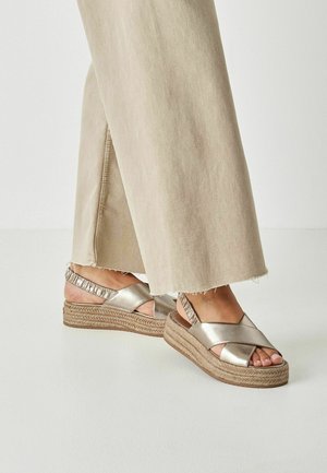 Metallicguld kilehøje sandaler med krydsede stropper og en flettet jute-sål. Har en rynket bagstropp for ekstra komfort.