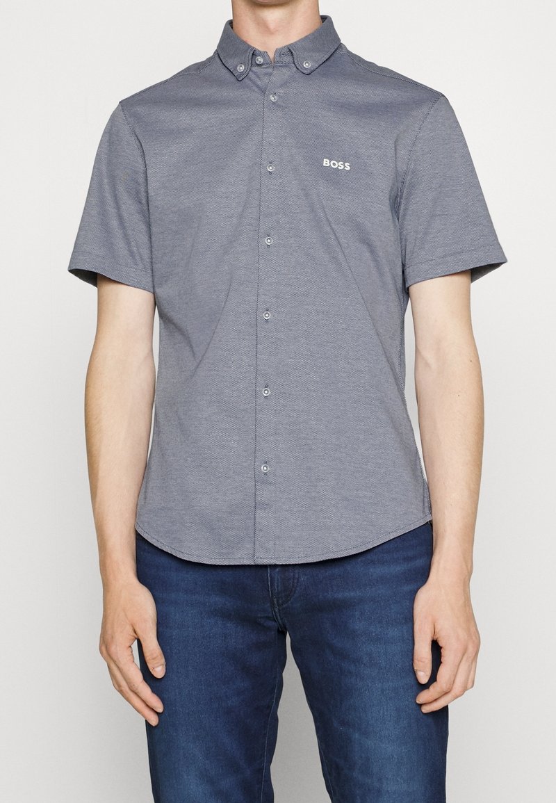 Koszula na krótki rękaw w ciemnoszarym kolorze, z teksturowanym wzorem i logo marki na piersi, z klasycznym kołnierzem i przeszyciami dekoracyjnymi.