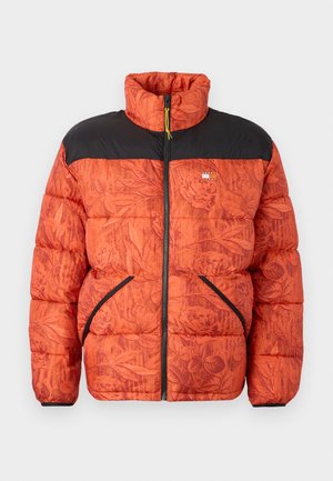 Puffer jacket featuring an orange floral pattern, black shoulders, front zip, and two side pockets with contrasting black trim.